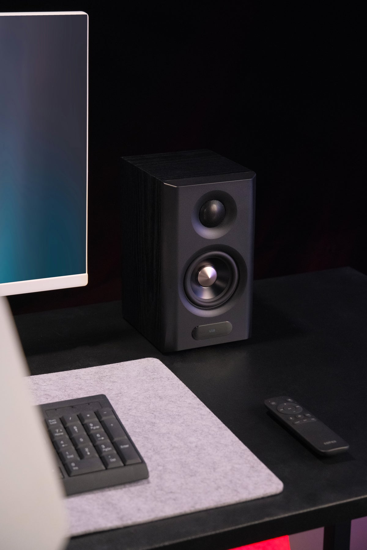 EDIFIER S355DB Black 2.1 speaker system right satellite speaker beside a monitor