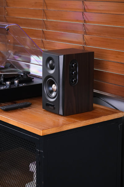 EDIFIER S355DB Walnut 2.1 speaker system satellite speaker beside a turntable